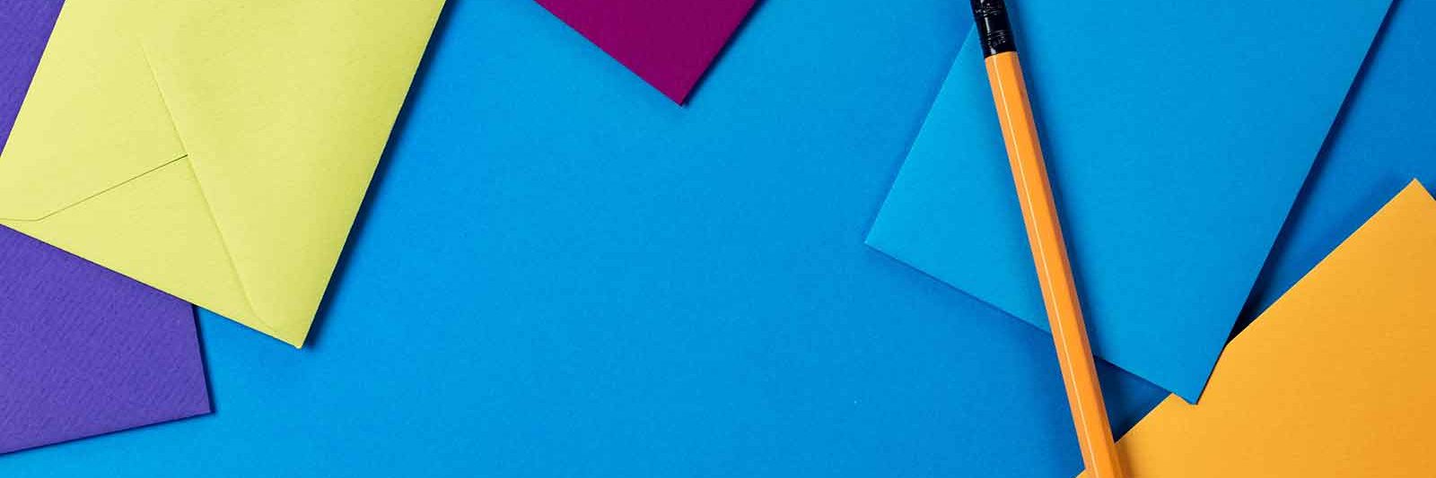 colorful envelopes and a pencil on a bright blue background
